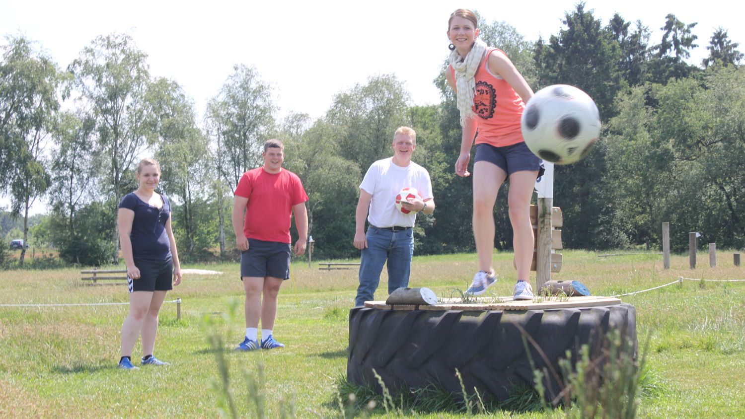 Eine Gruppe junger Menschen spielt Fußballgolf.