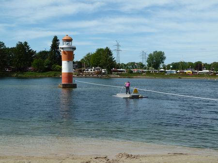 Ein Kind setzt vom Ufer mit dem Funfloß zum Leuchtturm im Bernsteinsee über