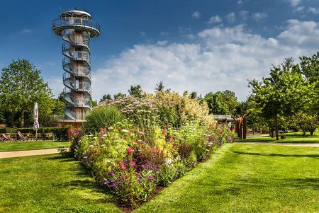 Imposantes Blumenbad und grüne Wiesen vor dem Aussichtsturm im Park der Gärten.