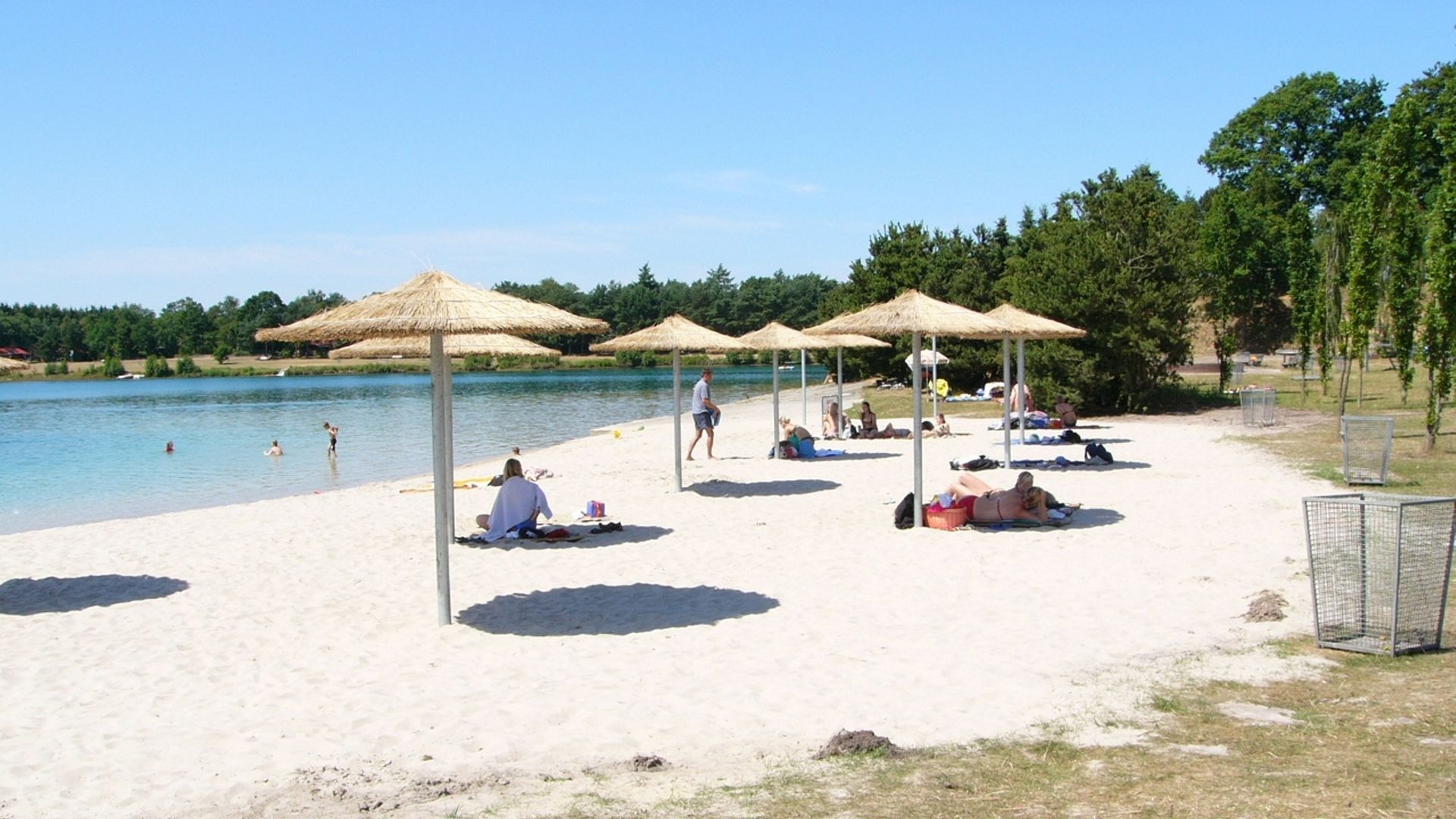 Sandstrand mit Sonnenschirmen am Bernsteinsee in Conneforde